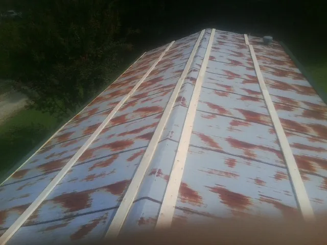 Rusted metal roof panels with new wood purlins before replacement — Storm Damage Roof Repair in Lafayette by Roofing Brothers